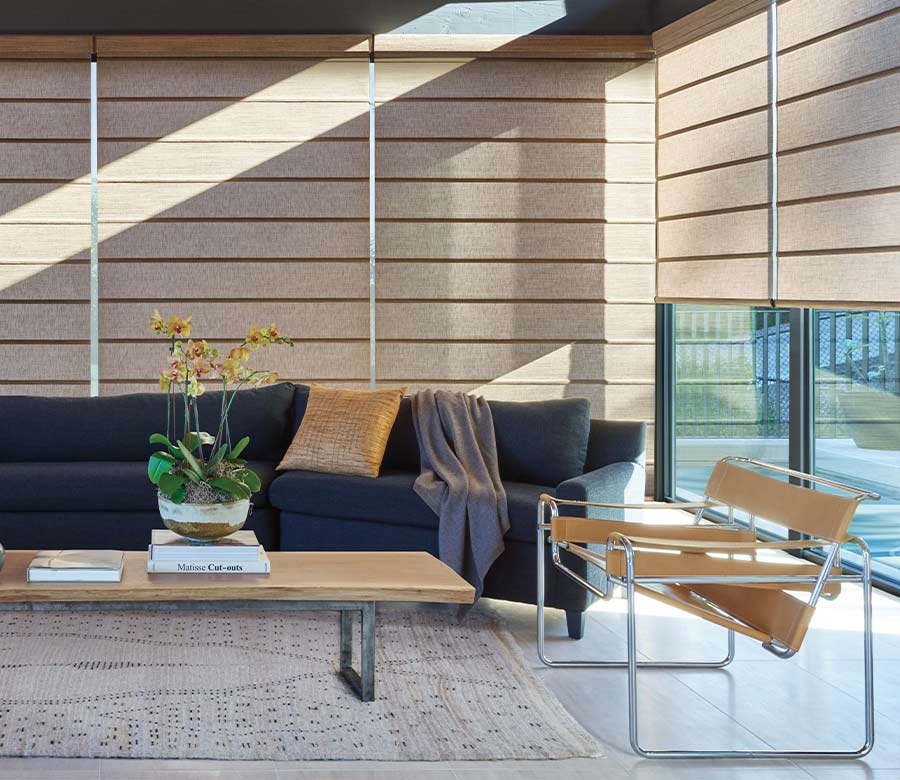 Two story windows in living room with beige roller window shades