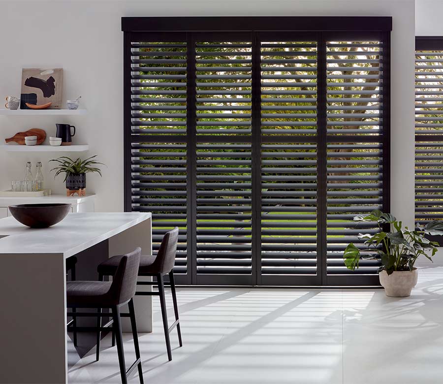 custom wood shutters on large window in kitchen for blocking direct sunlight