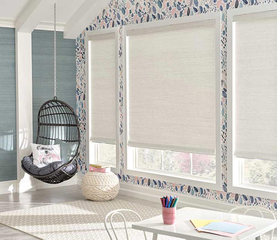 white hunter douglas shades in a natural woven wood material in kids playroom area