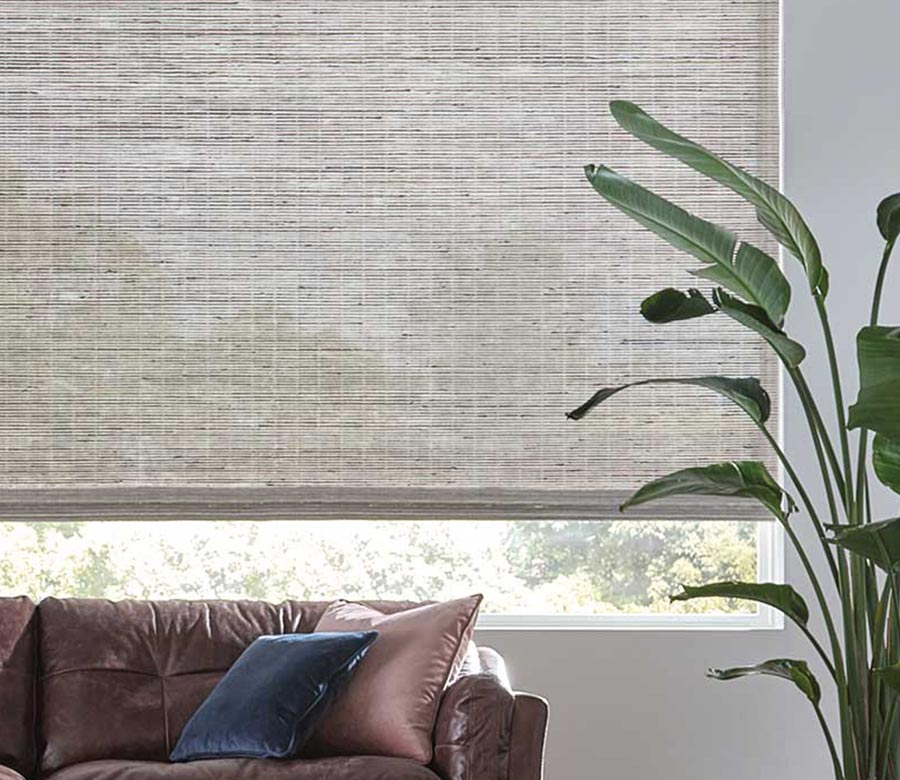 vertical woven shades in gray on large window in living room