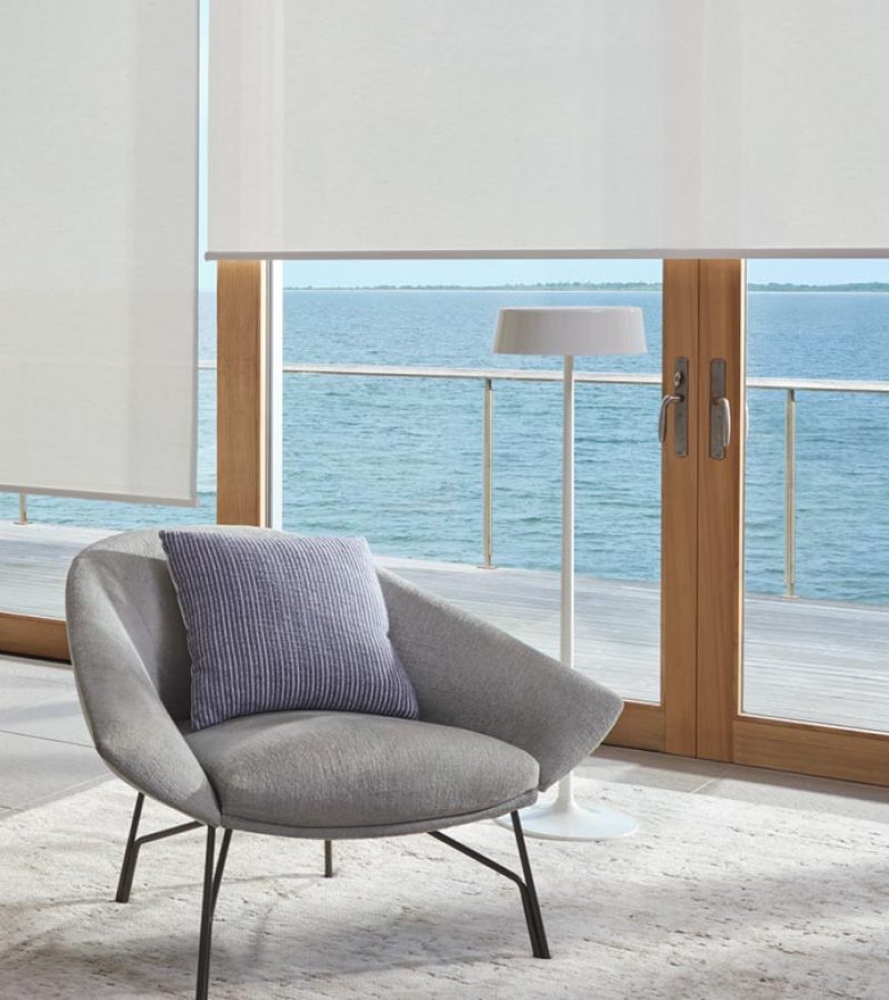 living area with gray couch and white screen shades